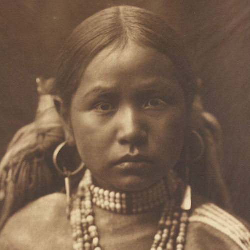 Photograph of young Native American girl of the Jicarilla tribe in traditional dress